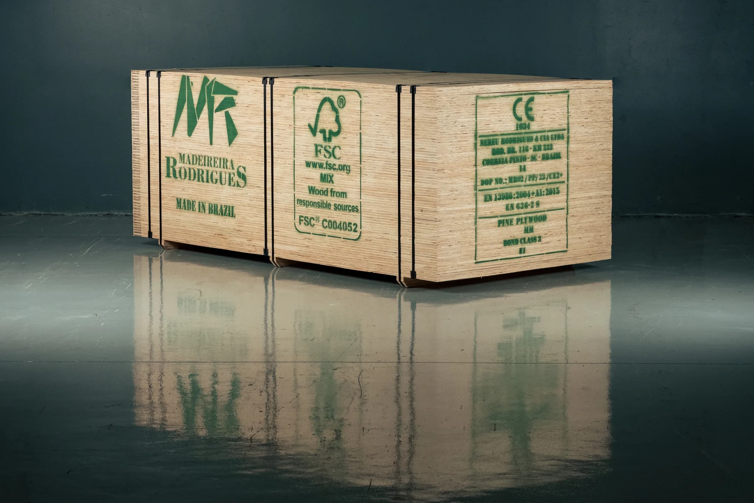 Fardos de compensado de pinus cintados, estampados com a marca Madeireira Rodrigues, o selo FSC e a marcação CE