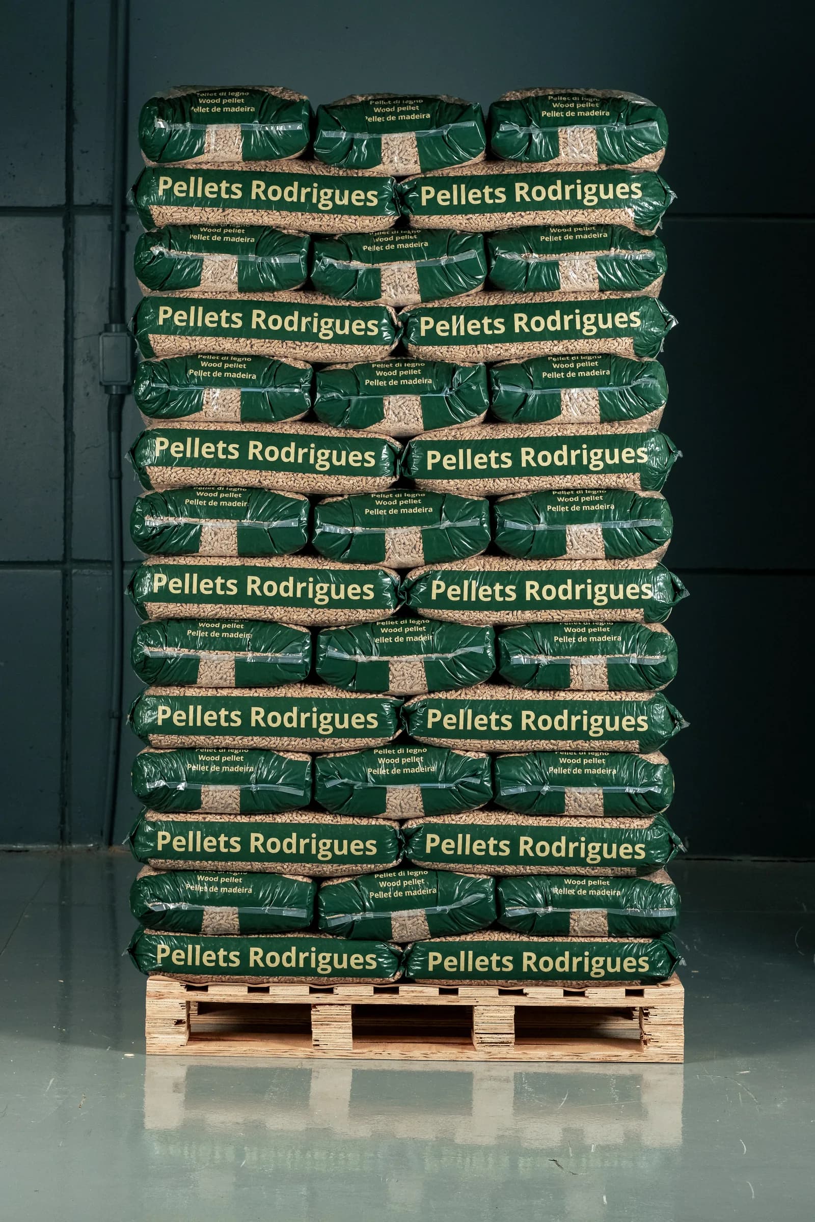 Palete alto de sacos de 15 kg de Pellets Rodrigues empilhados num galpão